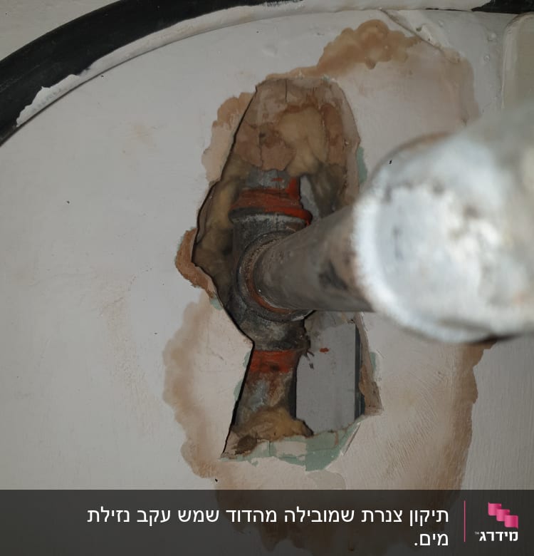 צינור מתכת בקיר עם סימני רטיבות